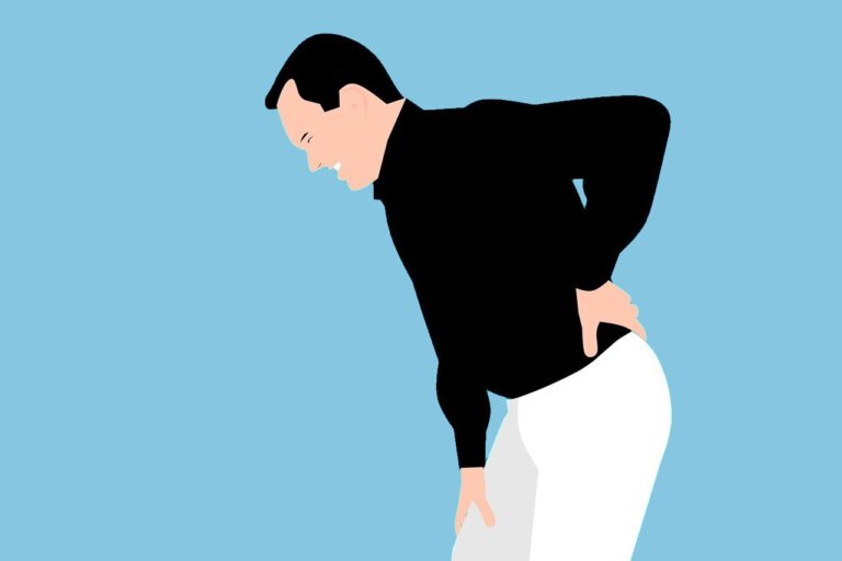 Ein Mann läuft gebeugt und hält sich vor Schmerzen den Rücken.