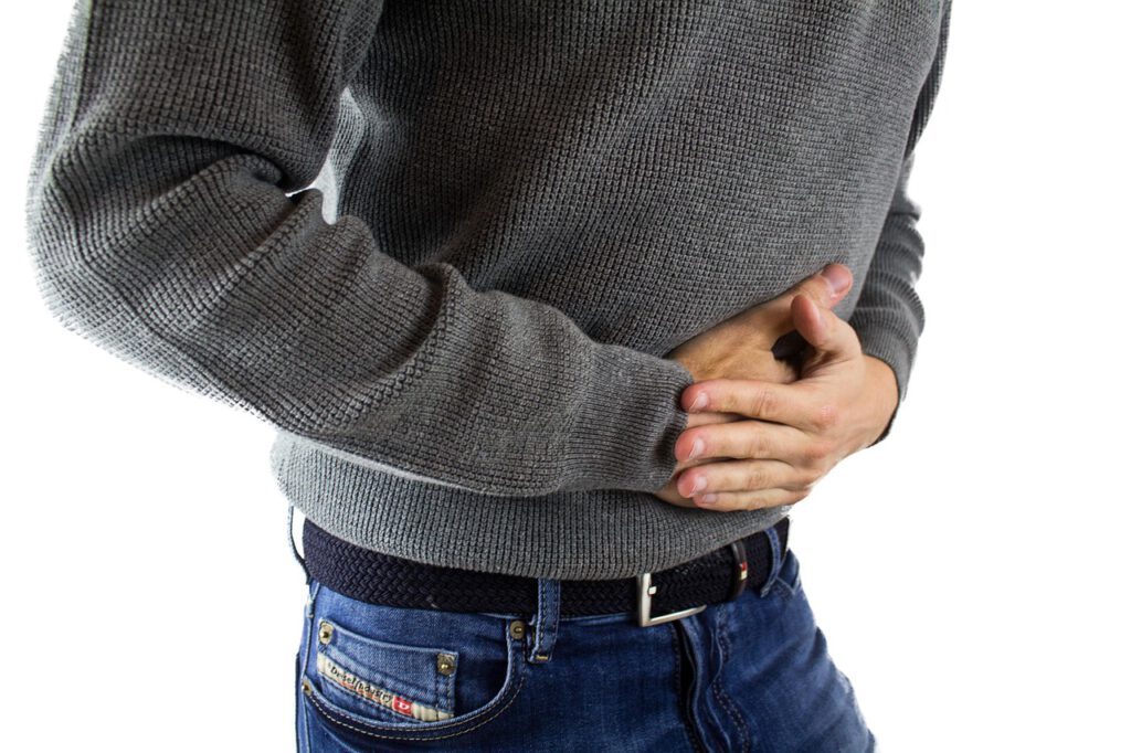Ein Mann mit Magen-Darm-Problemen hält sich den Bauch.